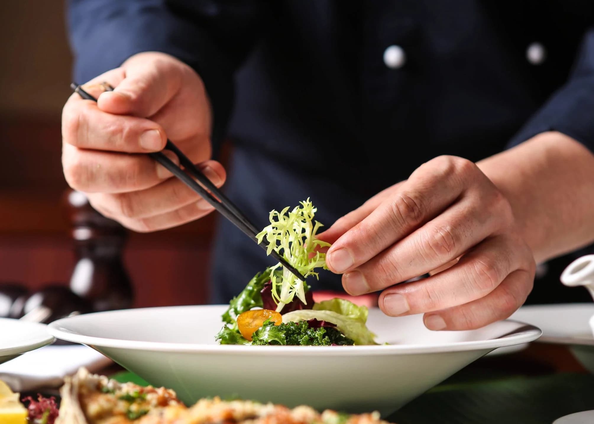 Chef preparando um prato da gastronomia da Mantiqueira